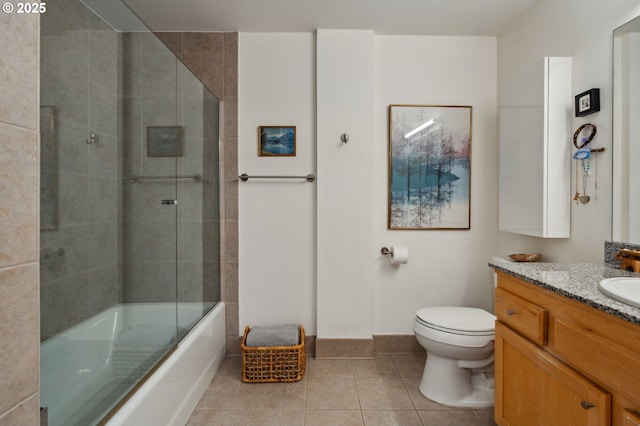 full bathroom featuring tile patterned floors, enclosed tub / shower combo, toilet, vanity, and baseboards