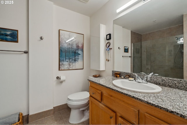 full bath featuring tile patterned floors, toilet, vanity, baseboards, and tiled shower