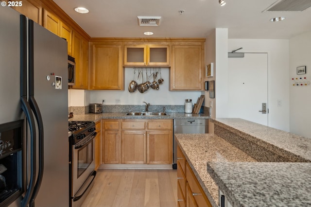 kitchen featuring appliances with stainless steel finishes, light wood-style floors, visible vents, and a sink