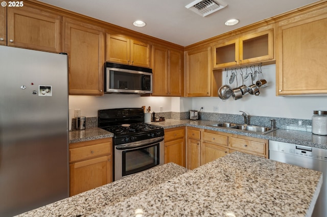 kitchen with recessed lighting, stainless steel appliances, visible vents, a sink, and glass insert cabinets
