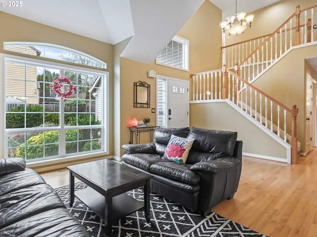 living room with hardwood / wood-style flooring, lofted ceiling, and a chandelier