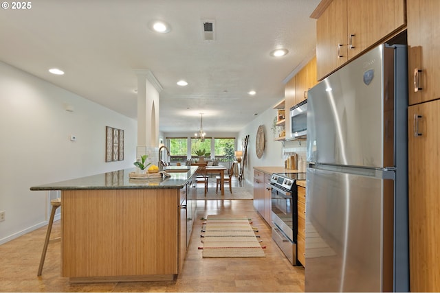 6708 N Richmond Ave, Portland, OR 97203 - kitchen featuring baseboards, a kitchen bar, recessed lighting, a chandelier, and stainless steel appliances