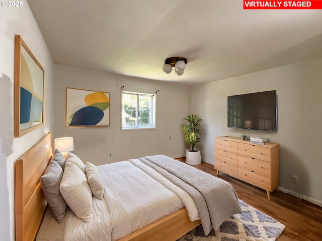 bedroom featuring wood finished floors and baseboards