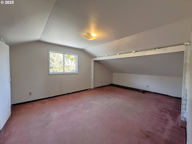 bonus room with vaulted ceiling, carpet flooring, and baseboards