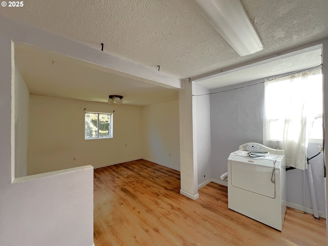 1042 Fir Ave, Reedsport, OR 97467 - laundry area with washer / clothes dryer, light wood finished floors, and a textured ceiling