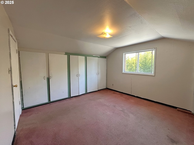1042 Fir Ave, Reedsport, OR 97467 - unfurnished bedroom featuring lofted ceiling, carpet floors, and two closets