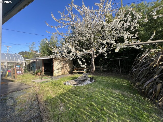 1042 Fir Ave, Reedsport, OR 97467 - view of green lawn with an outdoor structure and an exterior structure