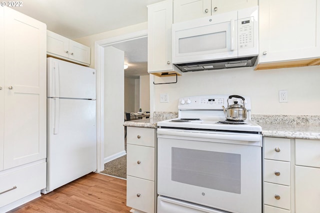 kitchen with white appliances, light wood-style floors, light stone countertops, and white cabinets