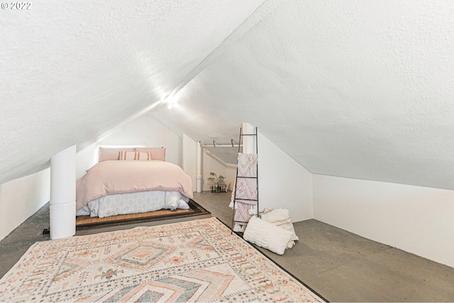 bedroom featuring vaulted ceiling and a textured ceiling