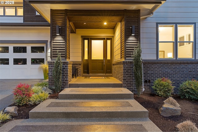 doorway to property with brick siding and an attached garage