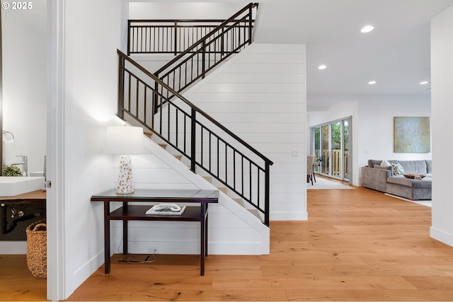 stairway featuring baseboards, wood finished floors, and recessed lighting