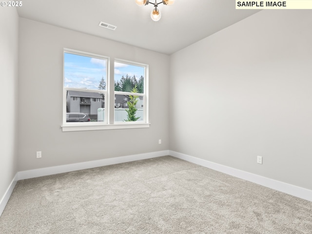 carpeted empty room with visible vents and baseboards