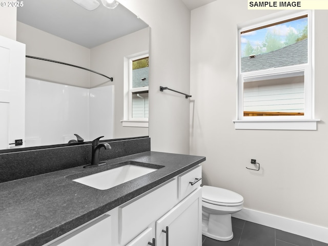 bathroom featuring baseboards, toilet, tile patterned flooring, walk in shower, and vanity