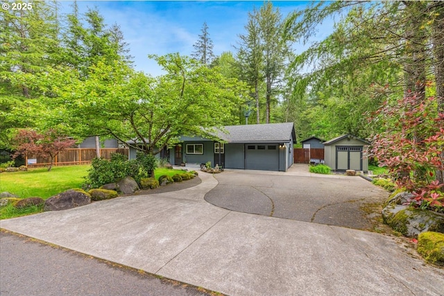 ranch-style home featuring an attached garage, asphalt driveway, a storage unit, and an outdoor structure