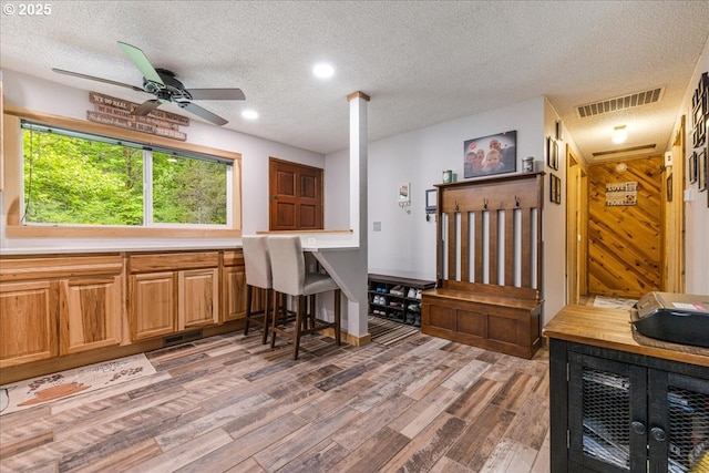 kitchen featuring light wood-type flooring, a textured ceiling, a ceiling fan, light countertops, and recessed lighting