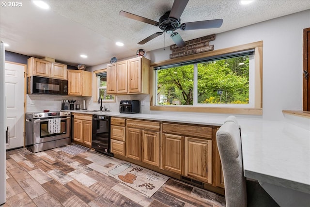 kitchen with black appliances, light wood finished floors, light countertops, recessed lighting, and a sink