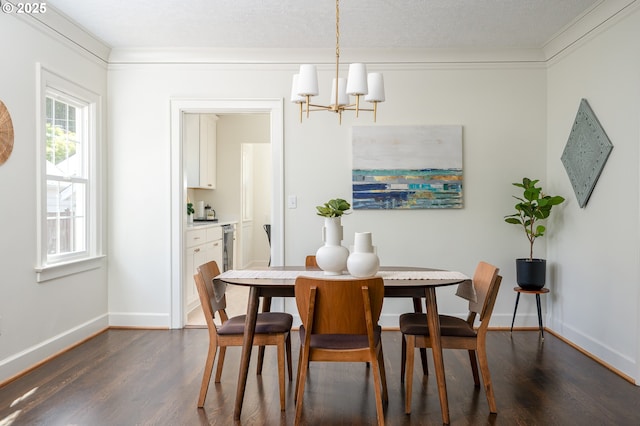 7327 N Washburne Ave, Portland, OR 97217 - dining room with dark wood finished floors, a chandelier, baseboards, and crown molding