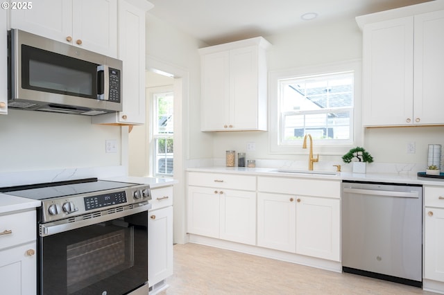 7327 N Washburne Ave, Portland, OR 97217 - kitchen featuring appliances with stainless steel finishes, a sink, light countertops, and healthy amount of natural light