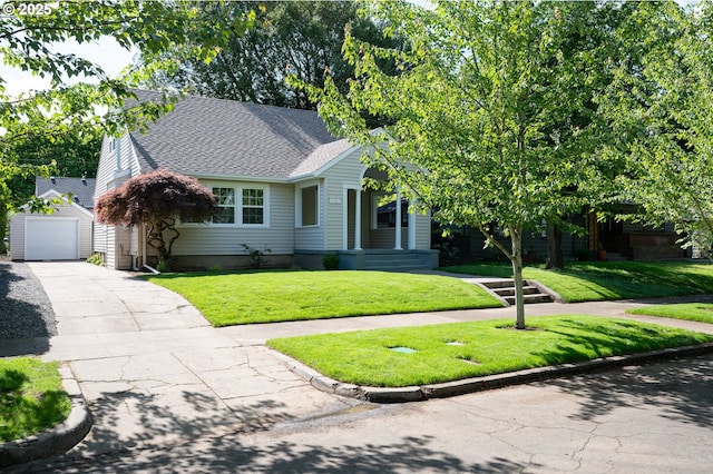 7327 N Washburne Ave, Portland, OR 97217 - view of front facade with an outbuilding, a shingled roof, asphalt driveway, a front yard, and a garage
