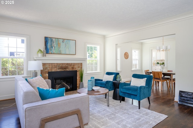 7327 N Washburne Ave, Portland, OR 97217 - living room featuring a glass covered fireplace, wood finished floors, a chandelier, plenty of natural light, and crown molding