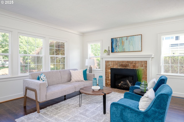 7327 N Washburne Ave, Portland, OR 97217 - living room featuring wood finished floors, baseboards, a tile fireplace, and crown molding