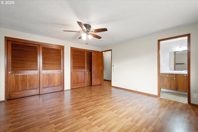 4603 SE 16th Ct, Gresham, OR 97080 - unfurnished bedroom with light wood finished floors, multiple closets, ensuite bathroom, a textured ceiling, and ceiling fan