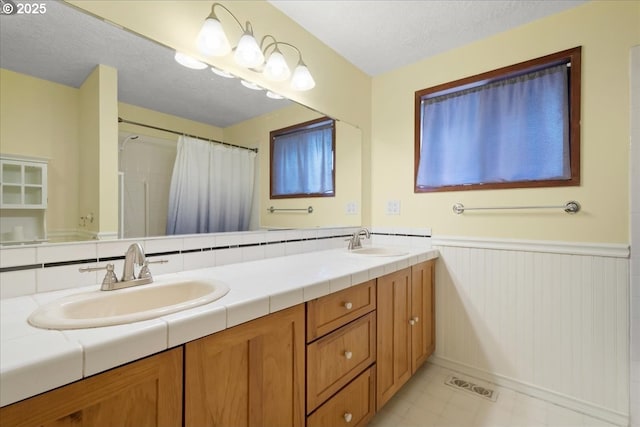 4603 SE 16th Ct, Gresham, OR 97080 - bathroom with a wainscoted wall, double vanity, a shower with shower curtain, and a textured ceiling