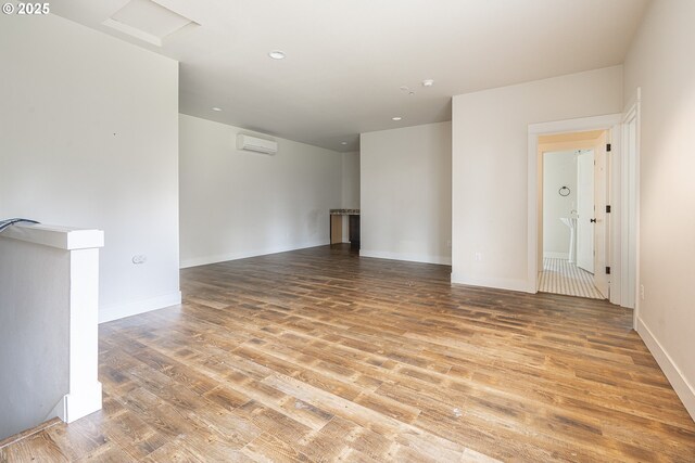 39665 SE Rude Rd, Sandy, OR 97055 - empty room with wood finished floors, a wall unit AC, baseboards, and recessed lighting