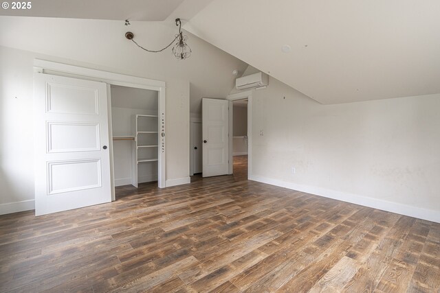 39665 SE Rude Rd, Sandy, OR 97055 - unfurnished bedroom with lofted ceiling, a wall mounted AC, wood finished floors, baseboards, and a closet