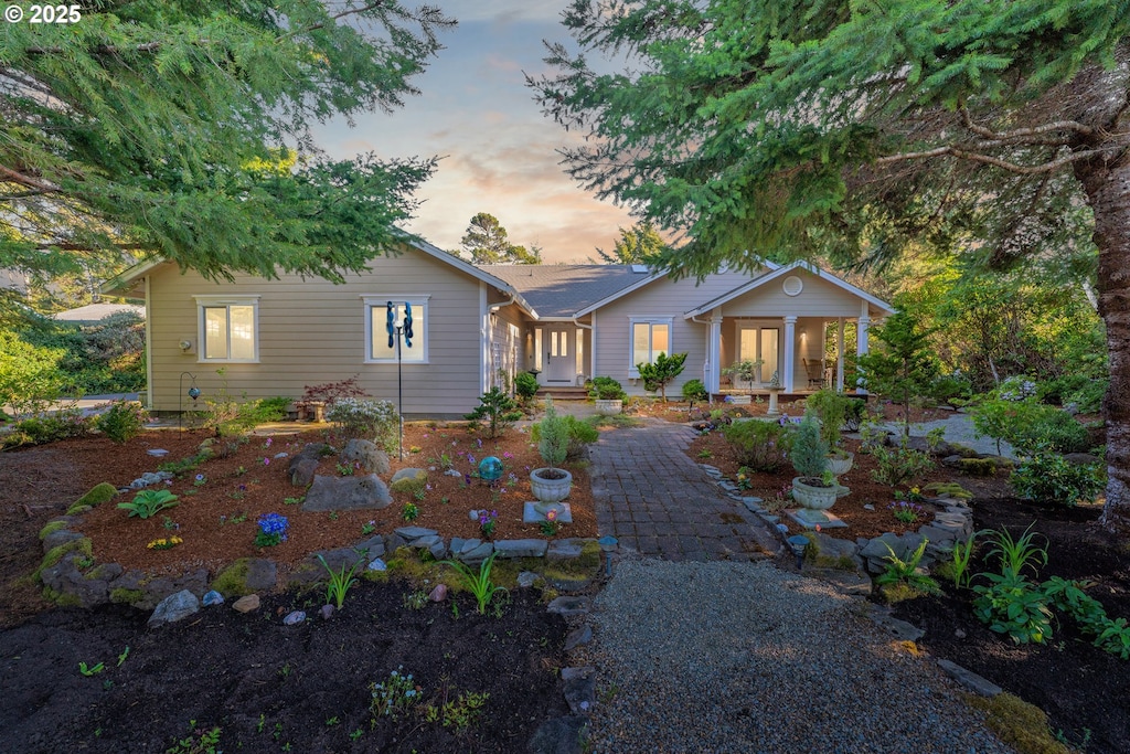 back of house at dusk featuring covered porch