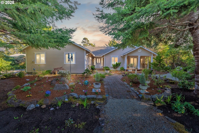 back of house at dusk featuring covered porch