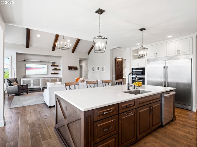 13848 SE Diamond Ridge Rd, Happy Valley, OR 97086 - kitchen with stainless steel appliances, a barn door, a sink, white cabinets, and dark wood-style floors