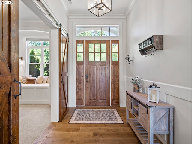 13848 SE Diamond Ridge Rd, Happy Valley, OR 97086 - entrance foyer featuring plenty of natural light, hardwood / wood-style flooring, crown molding, a barn door, and a chandelier