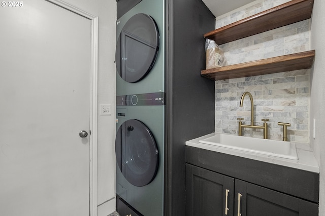 laundry area featuring stacked washer and clothes dryer and cabinet space