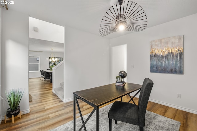 office featuring a chandelier, light wood-type flooring, and baseboards