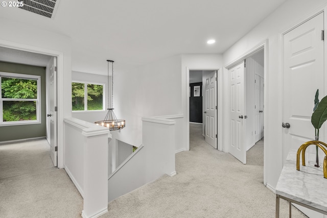 corridor with an upstairs landing, light carpet, baseboards, and recessed lighting