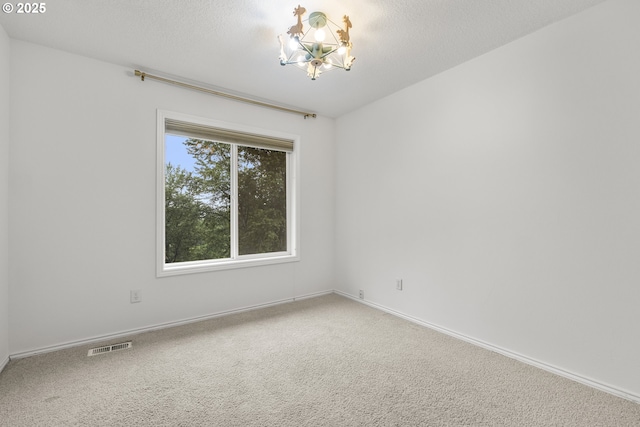 unfurnished room featuring a chandelier, carpet, and baseboards