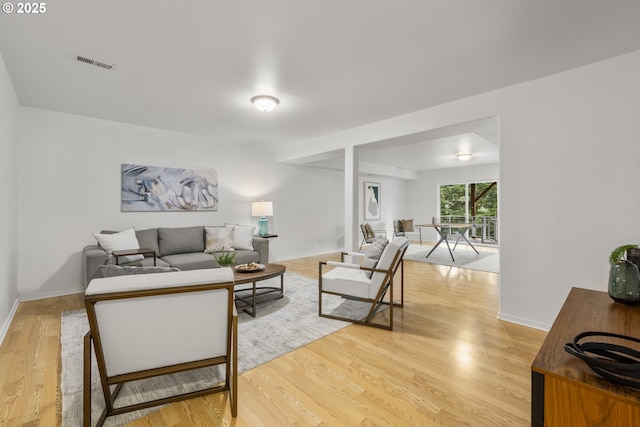 living area with light wood-type flooring and baseboards