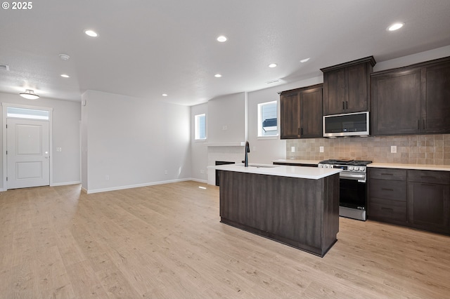 195 SE Acacia Dr, Gresham, OR 97080 - kitchen with appliances with stainless steel finishes, tasteful backsplash, light countertops, a kitchen island with sink, and recessed lighting