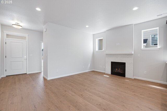 195 SE Acacia Dr, Gresham, OR 97080 - unfurnished living room with light wood-style floors, a fireplace, and recessed lighting