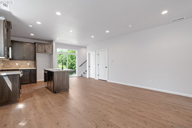 195 SE Acacia Dr, Gresham, OR 97080 - kitchen featuring range, light wood-style floors, dark brown cabinetry, recessed lighting, and tasteful backsplash