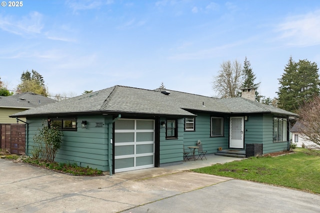 view of front of property with a garage, driveway, a chimney, roof with shingles, and a front lawn