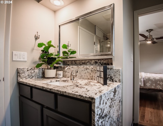 ensuite bathroom with ceiling fan, vanity, and ensuite bath