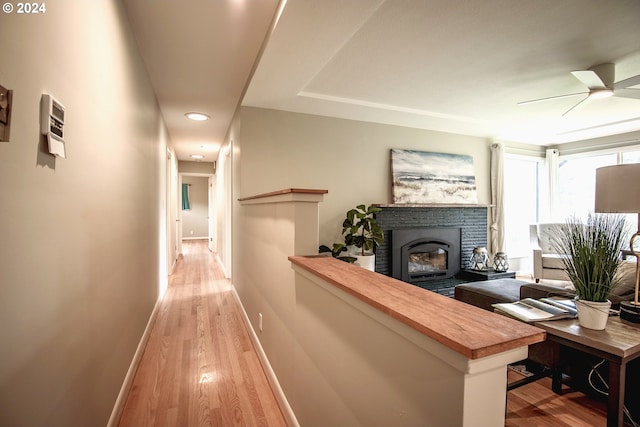 hall with light wood-style flooring and baseboards