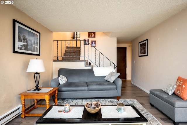 living room with hardwood / wood-style flooring, baseboard heating, and a textured ceiling