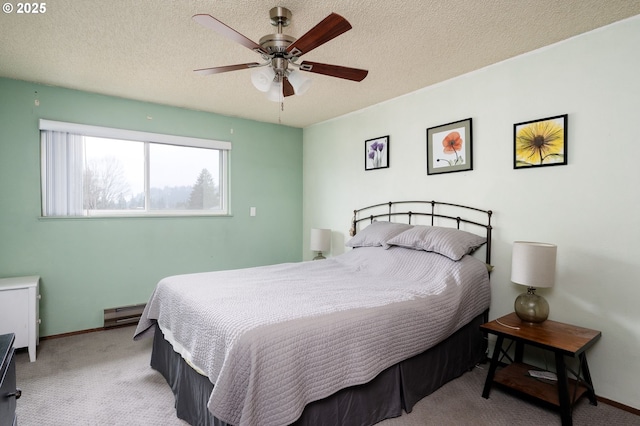 bedroom with ceiling fan, light carpet, a textured ceiling, and a baseboard radiator