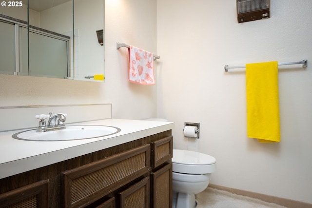 bathroom with toilet, vanity, and walk in shower