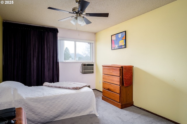 bedroom featuring light carpet, ceiling fan, a textured ceiling, and a wall mounted air conditioner