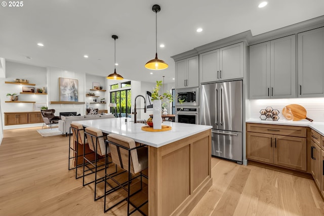 3800 W 2nd St, Washougal, WA 98671 - kitchen with appliances with stainless steel finishes, a breakfast bar area, light countertops, light wood-style floors, and recessed lighting