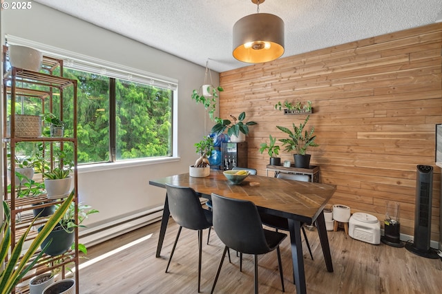 6745 SW Scholls Ferry Rd Unit 10, Beaverton, OR 97008 - dining area featuring a baseboard heating unit, wooden walls, a textured ceiling, and wood finished floors